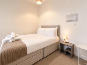 a small bedroom with a bed and a sink at Modern new redeveloped studio Apartment in Clacton in Clacton-on-Sea