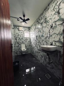 a bathroom with a sink and a toilet at Asoe living in Jorhat
