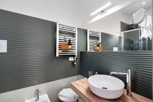 a bathroom with a sink and a toilet and a mirror at ByAma Holiday House in Menfi +34 photos