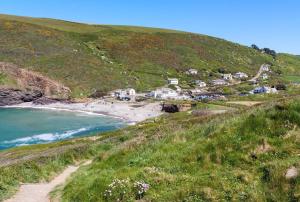 a view of a beach with houses on a hill at Boscastle Bell Tents in Boscastle +9 photos