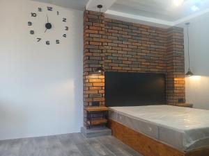 a brick wall with a bed and a clock on a wall at White House in Gyumri