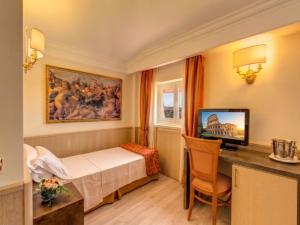 a hotel room with a bed and a desk with a television at Pinewood Hotel Rome in Rome