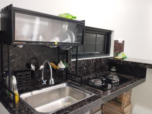 a kitchen counter with a sink and a microwave at Hasbi Homestay Syariah in Bukittinggi +91 photos