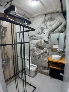 a stone bathroom with a toilet and a sink at White House in Gyumri
