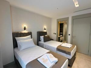 a hotel room with two beds with towels on them at Prime Bodrum Villas in Bodrum City