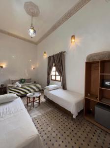 a bedroom with two beds and a window at Riad Fes Colors & SPA - Family Lodging in Fez