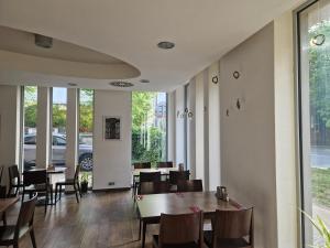 a dining room with tables and chairs and windows at Art Hotel Podebrady in Poděbrady +36 photos