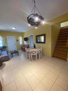 a living room with a table and a staircase at Roxys sea view Santorini Monolithos in Santorini
