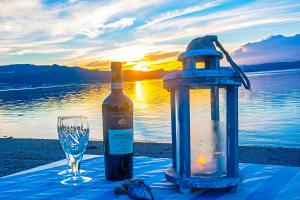 a bottle of wine next to a lantern and a glass at Strandheimen Guesthouse in Melhus