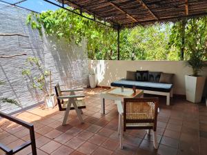 a patio with a couch and tables and chairs at Villa Lyvie ayurvedic hotel in Tangalle