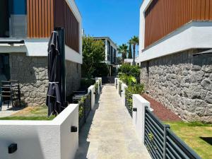 a walkway with umbrellas and a stone wall at Prime Bodrum Villas in Bodrum City