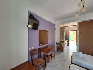 a living room with purple walls and a table and chairs at Kallisti in Finikounta