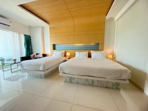 two beds in a hotel room with wooden ceilings at View Talay 6 Pattaya Beach Apartment by Honey in Pattaya +184 photos