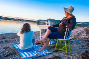 two women sitting on chairs on the beach at Strandheimen Guesthouse in Melhus