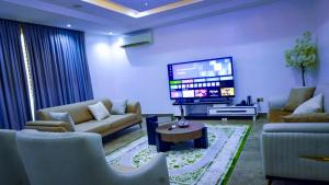 a living room with couches and a flat screen tv at Peev Apartments in Abuja