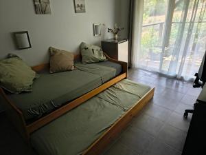 a bedroom with two beds and a large window at Chambre privative in Lecci