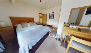 a bedroom with a bed and a dresser and a mirror at The Horse & Farrier in Otley