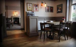 a dining room with a table and chairs and a fireplace at The Horse & Farrier in Otley