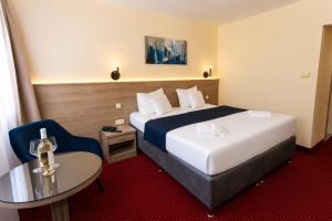ein Hotelzimmer mit einem Bett und einem Tisch in der Unterkunft Hotel Mediterran Budapest in Budapest + 24 Fotos