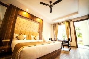 a bedroom with a large bed and a ceiling fan at DL Hotels & Resorts Corbett in Dhikuli