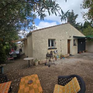a house with a table and chairs in front of it at Maison Lauret in Agde