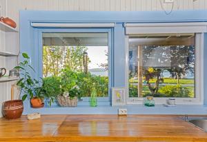 a kitchen with two windows with plants in them at Strandheimen Guesthouse in Melhus