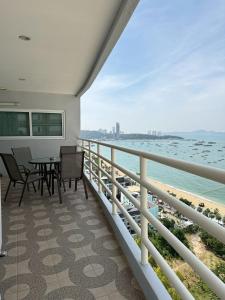 a balcony with a table and chairs and the ocean at View Talay 6 Pattaya Beach Apartment by Honey in Pattaya
