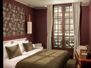 a bedroom with a large bed and a window at Lazare Nomade in Paris