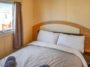 a bed sitting in a room with a window at The Getaway - Uk49617 in Lancaster +5 photos