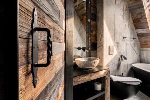 a bathroom with a wooden door and a sink at come home - bespoke villa in Kościelisko