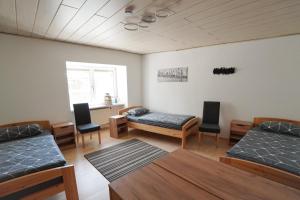 a room with two beds and a table and chairs at IBS Wohnen in Windischeschenbach