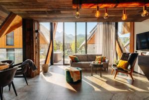 a living room with a couch and a large window at come home - bespoke villa in Kościelisko