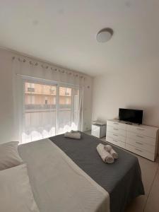 a white bedroom with a large bed and a window at D&F Guest House in Milazzo