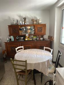 a dining room with a table and chairs and a cabinet at Dumas St-Germain de calberte in Saint-Germain-de-Calberte