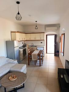 a kitchen and living room with a table and a dining room at Doukissa's Apartment in Symi