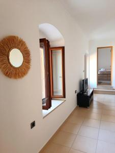 a room with a mirror and a tv on a wall at Doukissa's Apartment in Symi