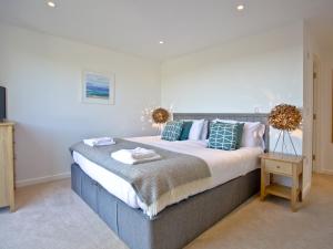 a bedroom with a large bed and a table at Una Aurum 56 in St Ives +27 photos