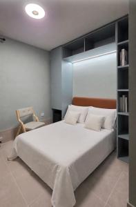 a bedroom with a large white bed and a chair at The Bubble in Madrid +7 photos
