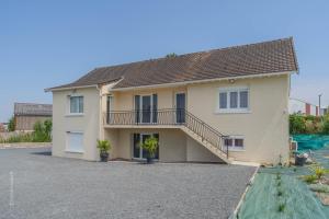 a house with a balcony and a driveway at L'Interdit, Confort et Sensualité in La Ferté-Gaucher