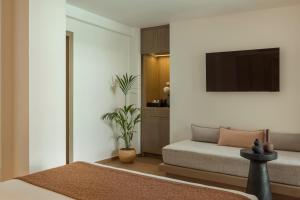 a bedroom with a bed and a flat screen tv at LAN-GO SIVOTA Luxury Living in Syvota