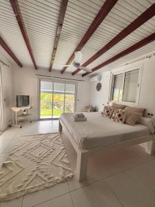 a bedroom with a large bed in a room with windows at Co and co habitation in Lamentin