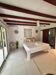 a bedroom with a white bed and a ceiling at Co and co habitation in Lamentin