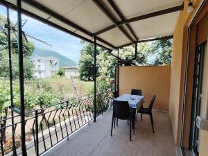 a patio with a table and chairs on a balcony at Biagio and Marias house in Trecchina
