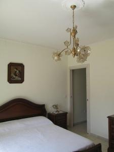 a bedroom with a bed and a chandelier at Biagio and Marias house in Trecchina