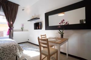 ein Esszimmer mit Tisch und Spiegel in der Unterkunft Justa casa Borgo Vittorio in Rom