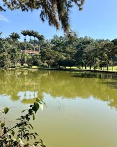 a park with a pond with trees in the background at Hotel Amoreiras in Extrema
