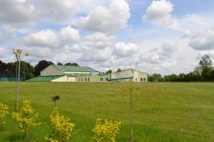 a large field with a building in the background at Noclegi Sezam in Łańcut