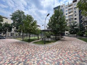 a brick road with trees and a street light at Hi-Tech Apartment in Tashkent
