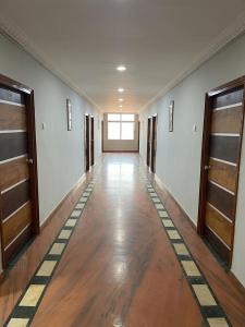 an empty hallway with wood floors and wooden doors at Milan Hotel in Zahirābād