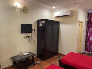 a living room with a black cabinet and a tv at Milan Hotel in Zahirābād